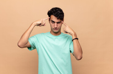 young handsome man with a serious and concentrated look, brainstorming and thinking about a...