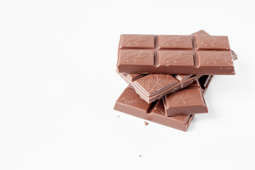 Milk chocolate pieces isolated on white background from top view, close up a chocolate bar isolated on white background