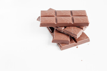 Milk chocolate pieces isolated on white background from top view, close up a chocolate bar isolated on white background