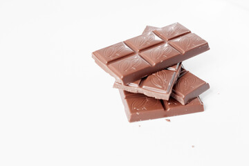Milk chocolate pieces isolated on white background from top view, close up a chocolate bar isolated on white background