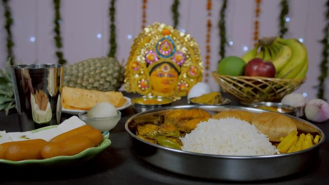 Decorated Puja room during Durga Puja festival with Bhog/Prasad items. A plate full of Bengali sweets/Langcha and Sandesh with traditional thali of West Bengal offered to Ma Durga during a Hindu fe...