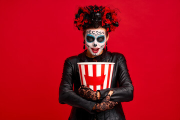 Girl with sugar skull makeup, with a wreath of flowers on her head and skull, wearth lace gloves...
