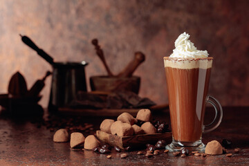 Truffles and glass of hot chocolate with whipped cream.