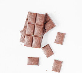 Milk chocolate pieces isolated on white background from top view, close up a chocolate bar isolated on white background