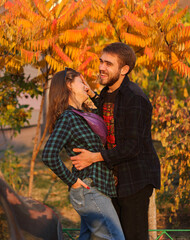 Couple in autumn. Portrait of couple. Couple in love. Man and woman at the street. Couple are hugging. Couple are laughing.