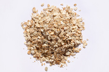 Large oatmeal top view. Raw oatmeal flakes on a white background. Useful grains for a healthy breakfast.