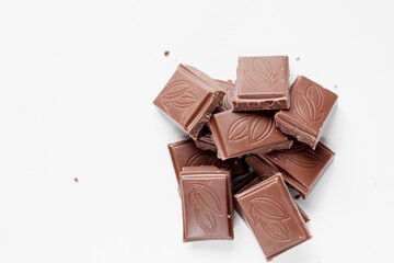 Milk chocolate pieces isolated on white background from top view, close up a chocolate bar isolated on white background