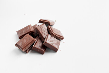 Milk chocolate pieces isolated on white background from top view, close up a chocolate bar isolated on white background