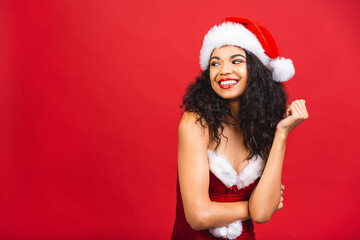 Beautiful smiling happy african american black woman in Santa Claus clothes isolated over red background. New year and christmas concept.