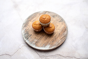 Mini muffins in paper cupcake holder on the wooden tray