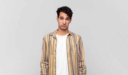 young handsome man feeling sad and stressed, upset because of a bad surprise, with a negative,...