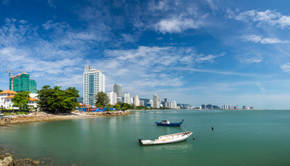Fototapeta premium Penang, Malaysia, Georgetown. City panorama at the sea coast promenade, hotel and fishing boat view.