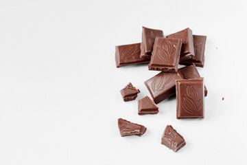 Milk chocolate pieces isolated on white background from top view, close up a chocolate bar isolated on white background