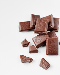 Milk chocolate pieces isolated on white background from top view, close up a chocolate bar isolated on white background