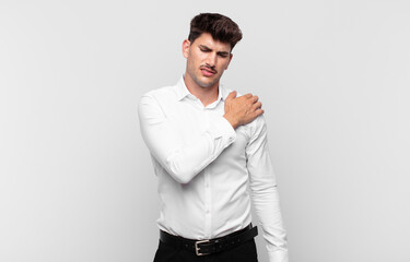 young handsome man feeling tired, stressed, anxious, frustrated and depressed, suffering with back...
