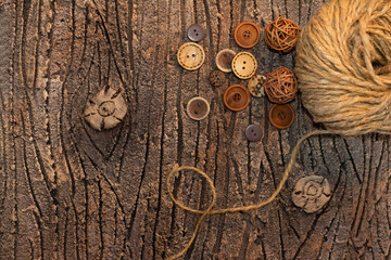 jute twine with buttons on brown bark of tree. Hobby background. Copy space