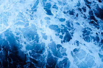Photo from above of white foam of ocean waves crashing