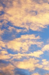 Clouds in the blue sky in the evening, during autumn, warm colours - background.