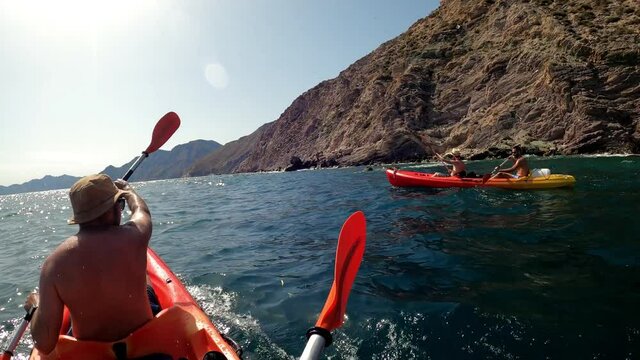 Kayakers group Kayaking in beautiful landscape at El Port&uacute;s, Cartagena, Spain. Kayakers in double kayak practicing sport. Aquatic sports duringsummer concept.
