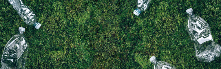 Plastic empty rumpled bottles on green moss background. Top view, copy space. Zero waste....