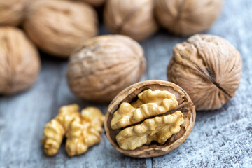 Ripe and raw whole big walnut kernel with thin shell on wooden rustic backdrop. Healthy nut food for brain. Fresh walnuts background concept