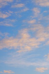 Clouds in the blue sky in the evening, during autumn, warm colours - background.