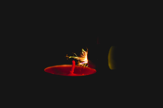 Instant&aacute;nea de las chispas de un mechero encendiendo una vela roja.