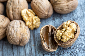 Ripe and raw whole big walnut kernel with thin shell on wooden rustic backdrop. Healthy nut food for brain. Fresh walnuts background concept