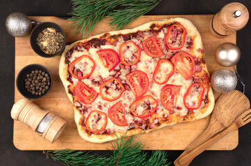 Happy New year and merry Christmas, pizza with cheese, tomatoes and bacon on a brown background. The view from the top. The concept of New year and Christmas.