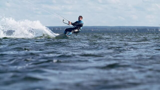 Professional kiter catching wind with his kite. Windy day on a coast