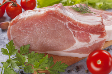 Raw pork steak with tomatoes and herbs.
