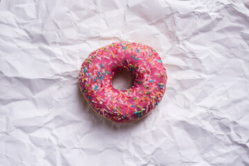 Pink donut on white paper background
