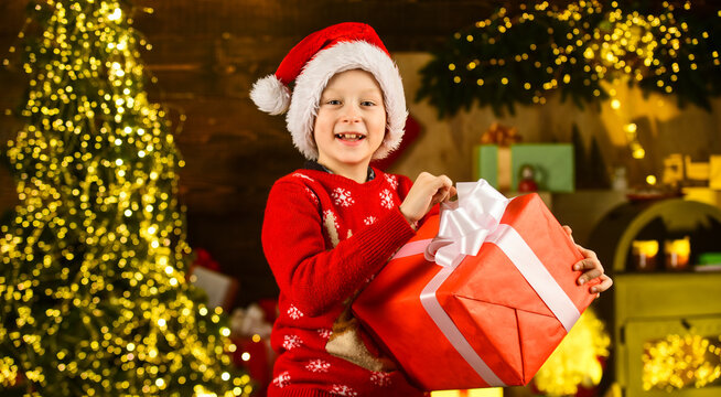 Merry christmas. Happy childhood concept. Kid wear santa hat and christmas sweater. Santa brought me gifts. December tradition. Sale discount. Real happiness. Child happy excited near christmas tree