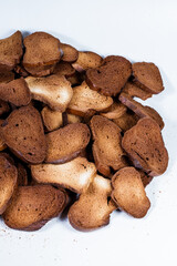 The texture of toasted pieces of bread. Croutons on a white background. Dark dry bread.