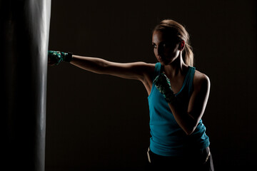 kick fighter girl punching a boxing bag