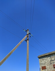 electric pole with wires against the blue sky
