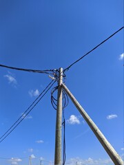 electric pole with wires against the blue sky