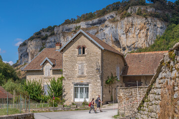 Fototapeta na wymiar Baume-Les-Messieurs, France - 09 01 2020: View of the village of Baume-les-Messieurs and cliffs behind