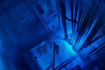 Blue glow water of nuclear reactor core powered, caused by Cherenkov radiation, fuel plates...