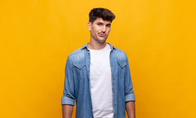 young handsome man feeling confused and doubtful, wondering or trying to choose or make a decision
