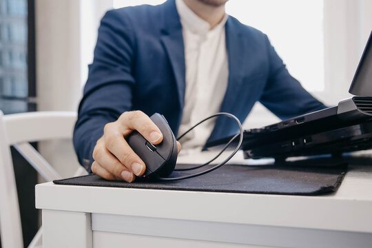 office worker uses an ergonomic vertical computer mouse