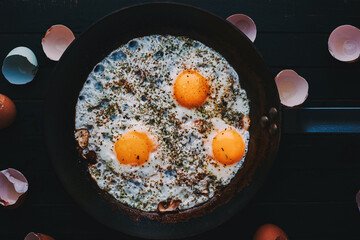 Homemade fried eggs with spices and mushrooms top view