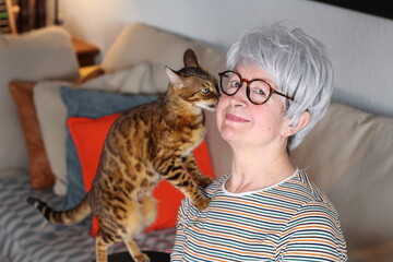 Senior woman with exotic bengal cat