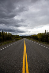 View of Scenic Road surrounded by Mountains and Trees on a Fall Day in Canadian Nature. Klondike Highway, Yukon, Canada.