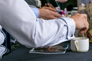 Fototapeta premium Businessman stirring a cup of coffee at conference