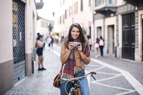 young woman takes a picture with a vintage camera