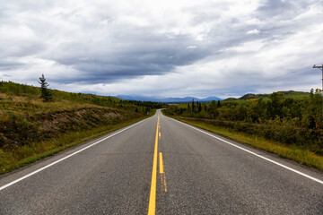 View of Scenic Road surrounded by Mountains and Trees on a Fall Day in Canadian Nature. Klondike Highway, Yukon, Canada.