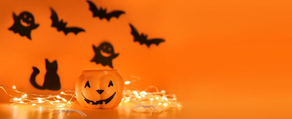 Happy Halloween! Pumpkin, bats, cat, ghost on an orange background and a glowing bokeh background. Banner, copy space for text