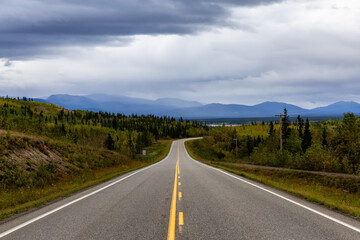 View of Scenic Road surrounded by Mountains and Trees on a Fall Day in Canadian Nature. Klondike Highway, Yukon, Canada.