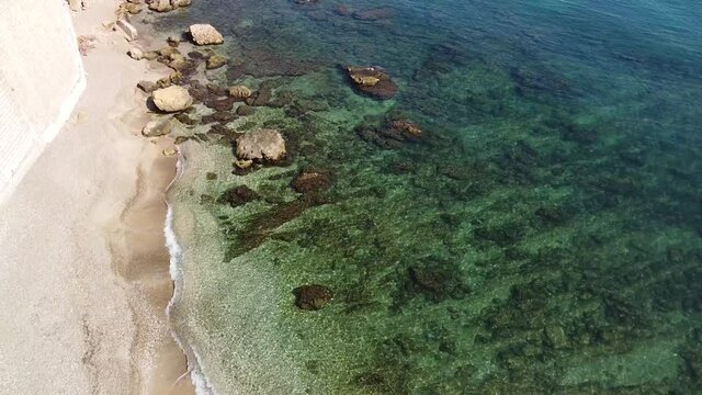 panoramica di una spiaggia di Castellammare del Golfo e del suo castello in lontananza.